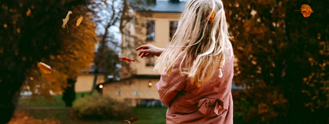 Barn leker i lövhög