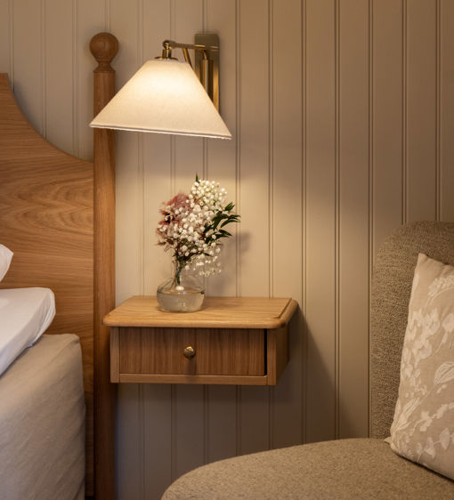 Vackra färska blommor står på nattygsbordet