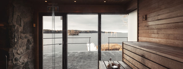 Vedeldad bastu med stora glasfönster och utsikt över Mälaren